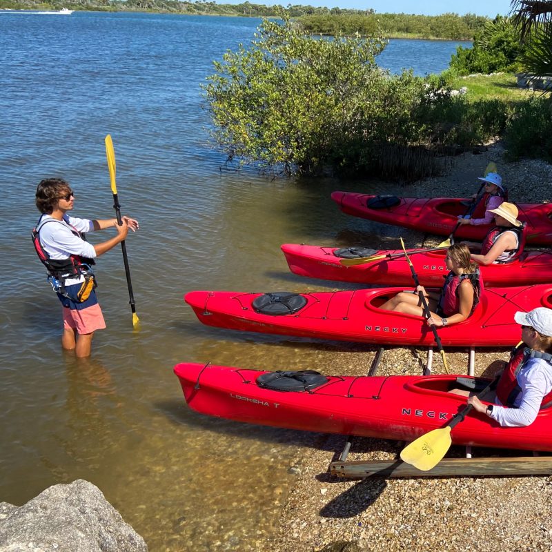 a group of people standing next to a body of water