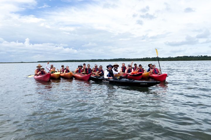 a group of people in a small boat in a body of water