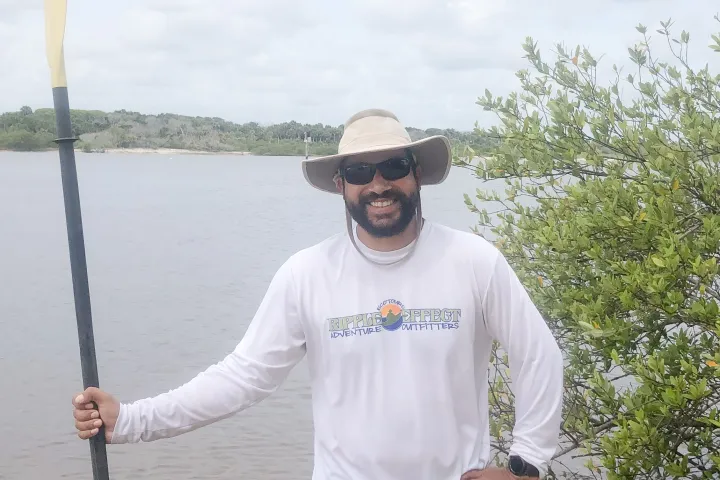 a man standing next to a lake