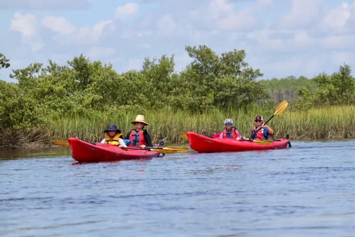 a family smiling during a Ripple Effect Ecotour guided kayak adventure tour