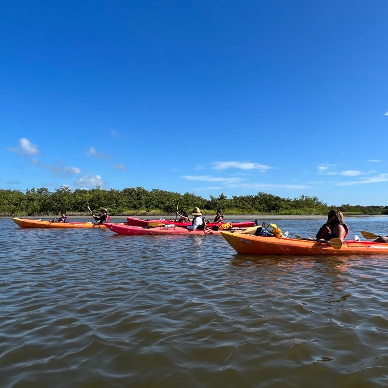 a group of people in a small boat in a body of water